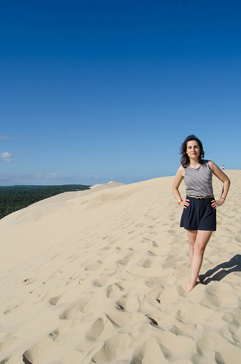 Young adult with a navy skirt on the Dune du Pyla, the biggest sund dune in Europe.