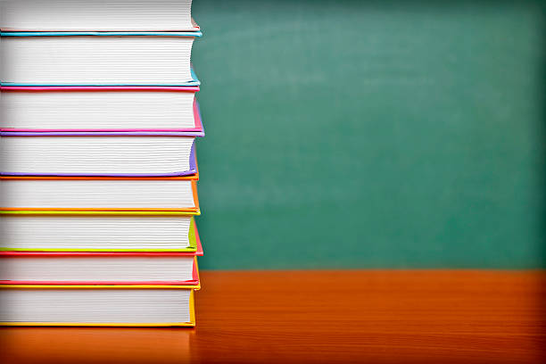 istock Stack of books on a green chalkboard background 578830298