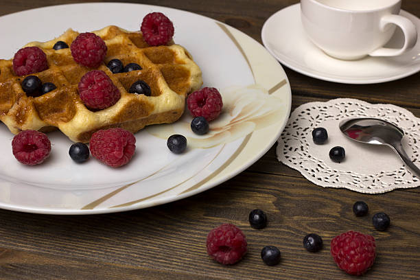 istock waffles in a white plate with berries on the table 578830654