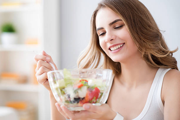 istock Nice joyful woman eating salad 578831018