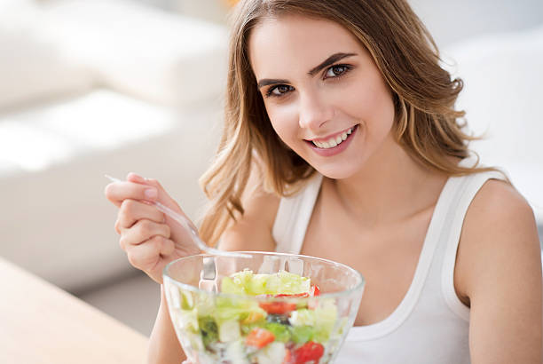 istock Positive delighted woman eating salad 578831038
