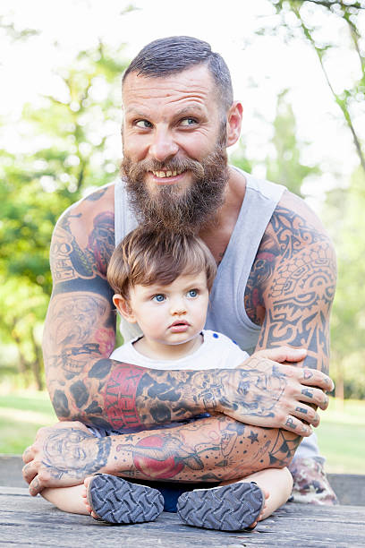 istock tattooed father have fun with his son in the park 578831472