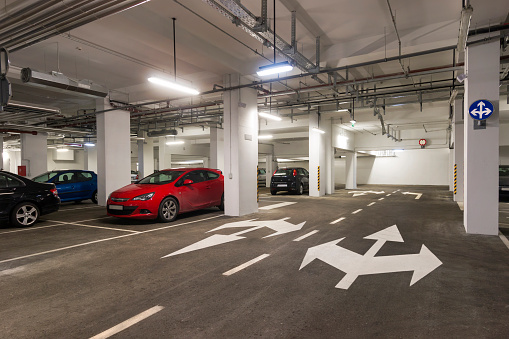 Interior of parking garage with car and vacant parking lot in parking building