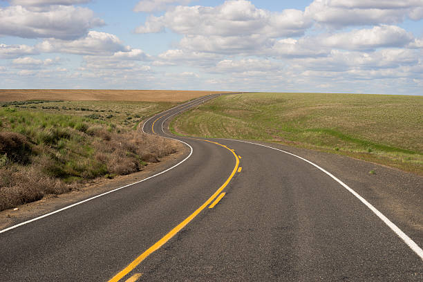 istock Paved Two Lane Road Highway Transportation White Clouds Blue Sky 578833610