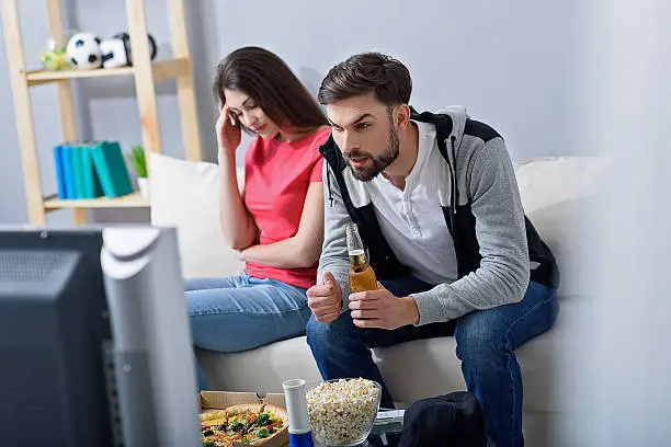 Photo of Man and woman watching tv on couch