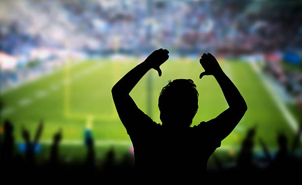 istock Man Raising Arms in Excitement at Sporting Event 578835602
