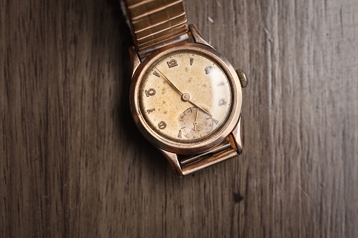 Vintage wristwatch on a wooden table. Classic watch