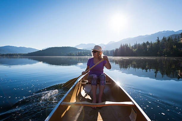 Senior aged woman canoeing on a pristine lake