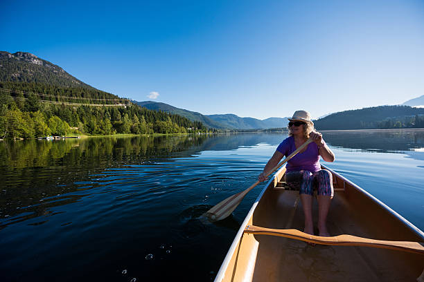 Penticton, British Columbia/Canada - December 28, 2020: a person paddles a kayak across Skaha Lake during the calm after a winter storm. The lake is often free of ice for most of winter.