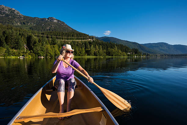 istock Senior aged woman canoeing on a pristine lake 578836134