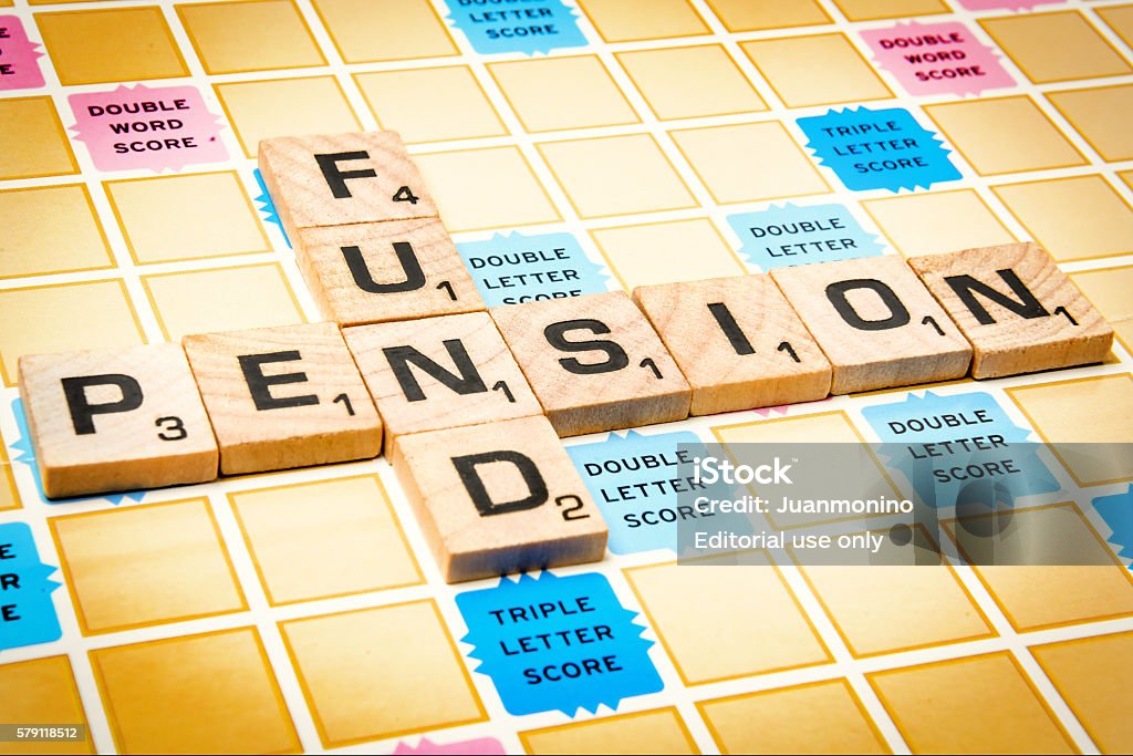 Pension Fund Miami, Florida, USA - December 2, 2015: Scrabble game board Lettered wooden tiles forming the Words "Pension Fund" over a scrabble game cardboard . Scrabble is a fun and educational game distributed by Hasbro Pension Stock Photo