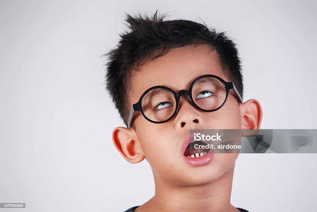 Little Boy Very Bored and Unhappy Portrait of Asian boy with glasses showing very lazy unhappy bored and tired gesture Boredom Stock Photo