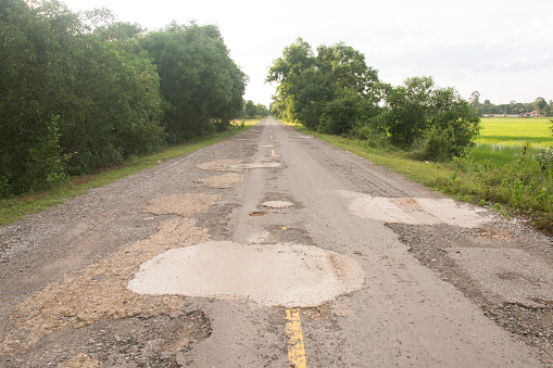 Damaged asphalt pavement road with potholes ,Asia