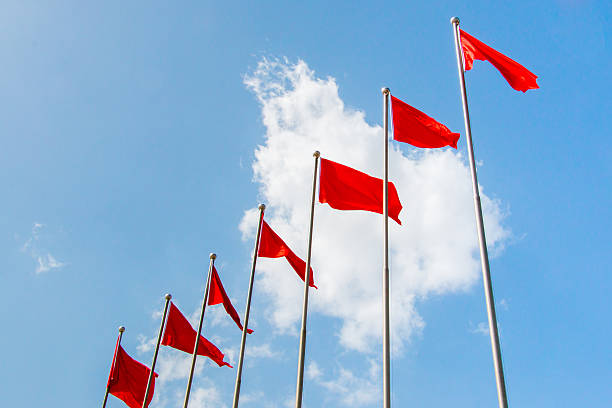 istock Row of red flag in front of blu sky 579124420
