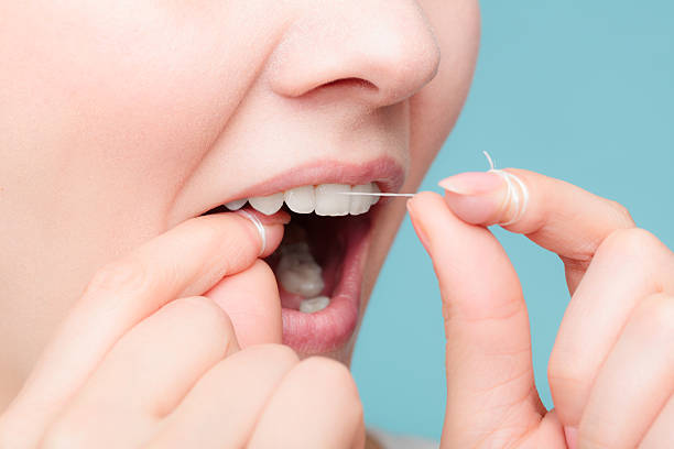 istock side view woman face smiling with dental floss. 579127616