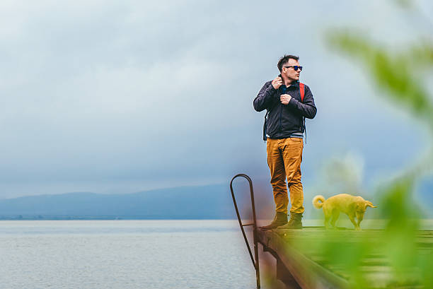 istock Man and his dog standing on a dock 579131308