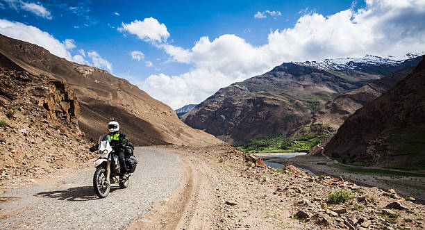 istock Man rides motorcycle off-road near river 579132448