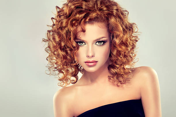 Pretty red-haired girl with curls. stock photo