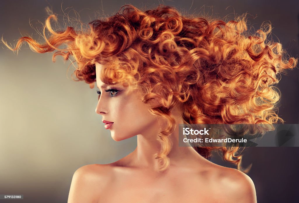 Pretty red haired girl with curly hairstyle. Pretty red haired girl with curly hairstyle.Flying hair in dynamic movement. Beauty Stock Photo