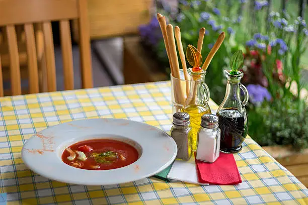 Italian serving of gaspacho. Table set with Italian spirit