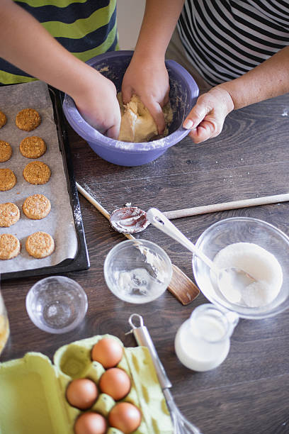istock Grandson Helping Grandmother To Bake coockies In Kitchen 579136084