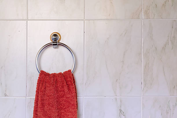 Red towel hanging on marble tile toilet wall stock photo
