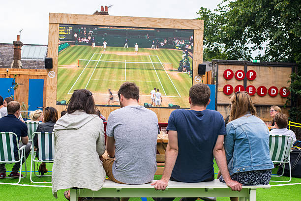 People talking and drinking in Pop Brixton, South London Brixton, London, United Kingdom - July 9, 2016: People talking and drinking while watching Wimbledon tennis match in a big outdoor screen in Pop Fields, part of the trendy venue Pop Brixton, South London. brixton photos stock pictures, royalty-free photos & images