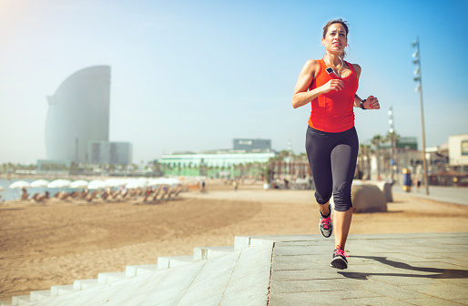 Mujer deportiva corriendo y entrenando junto a la playa photo
