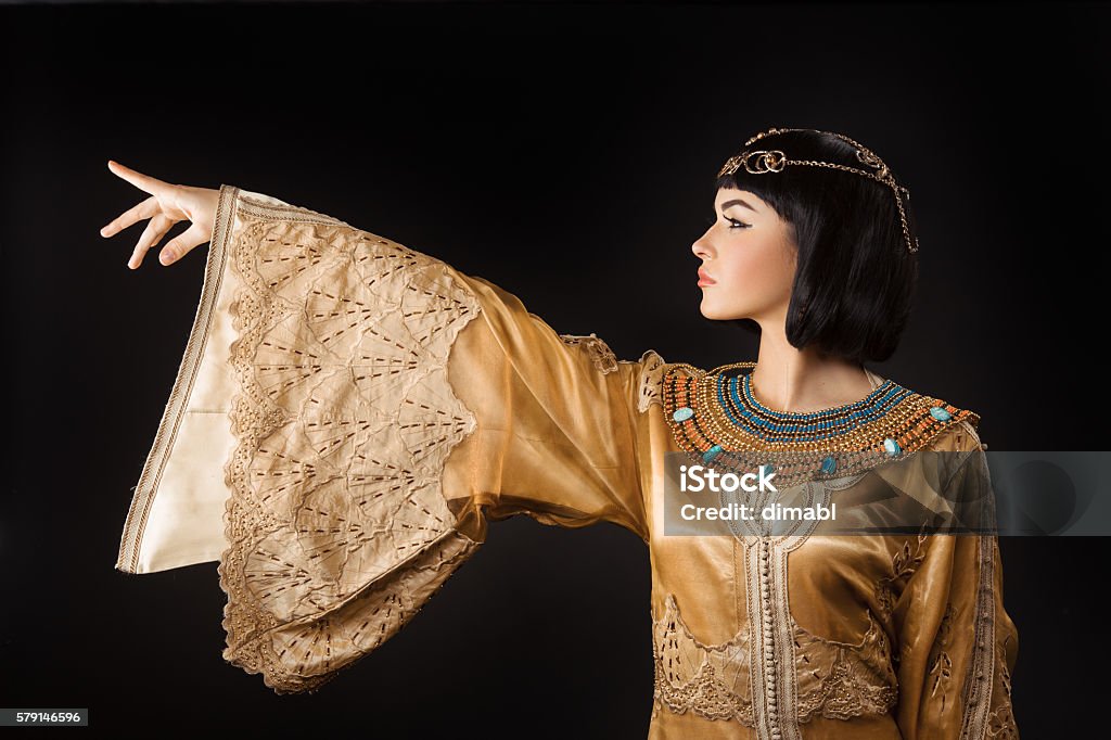 Beautiful Egyptian woman like Cleopatra pointing finger away on black Woman pointing finger. Glamorous closeup portrait of beautiful stylish brunette young model. Power orders Adult Stock Photo