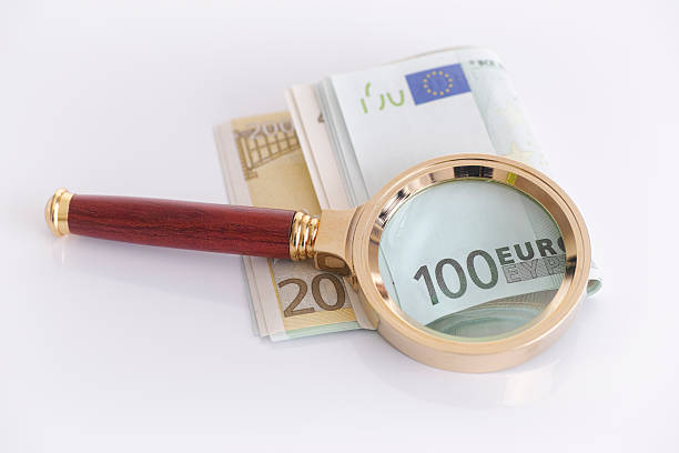 istock Magnifying glass and euro banknotes 579148512