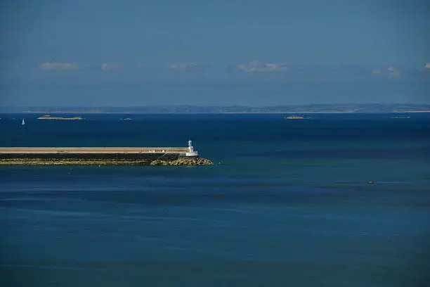Telephoto image of a breakwater and the coast of France.