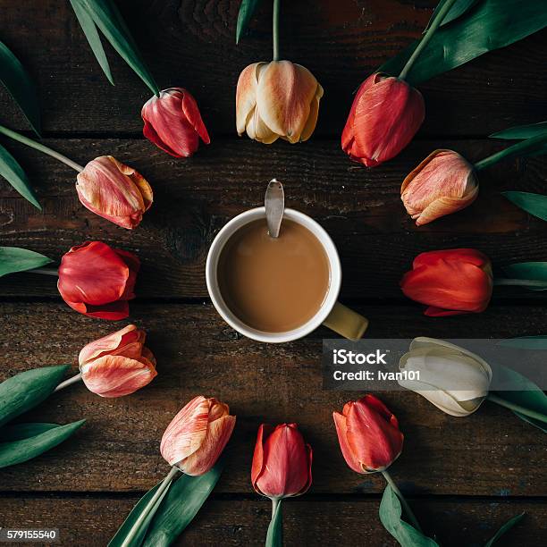 Coffee Cup With Creative Arrangement Of Tulips On Wooden Backgr Stock Photo - Download Image Now