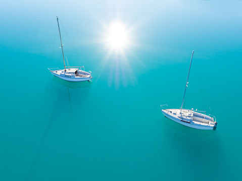 Beautiful aerial view of two yachts sailling on azure water