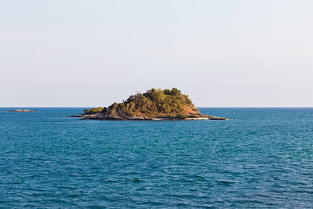 istock Small lonely island over seacoast skyline 579156014