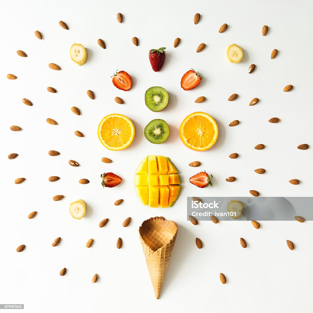 Creative layout of fresh fruits, nuts and ice cream cone. Creative layout of fresh fruits, nuts and ice cream cone. Flat lay. Summer concept. Exploding Stock Photo