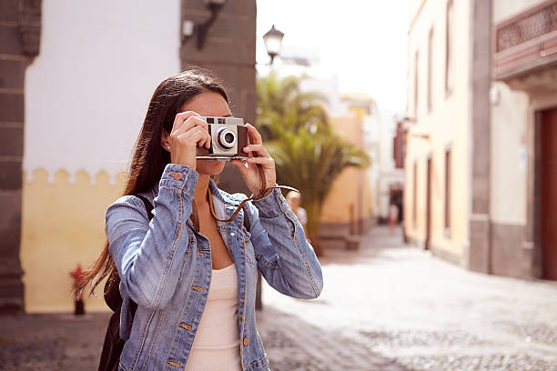istock Young girl focusing her old camera 579159258