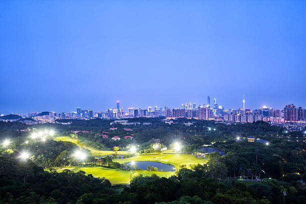 skyline of modern city with golf course at night skyline of modern city with golf course at night in guangzhou night golf stock pictures, royalty-free photos & images