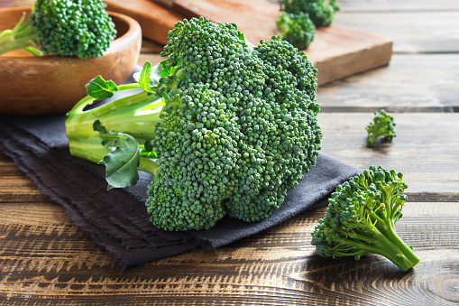 Healthy green organic raw broccoli on wooden table