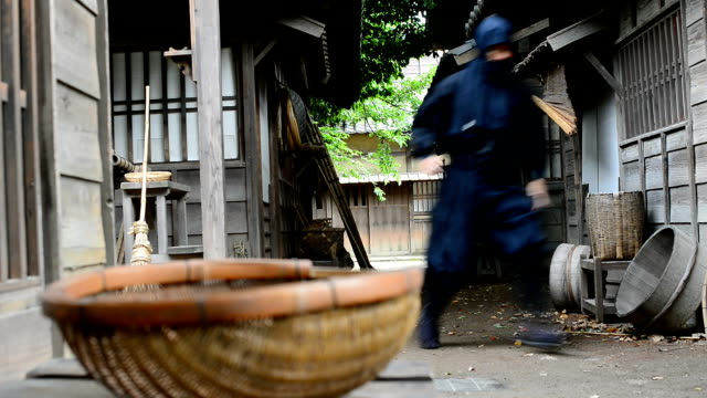 Real ninja in historical Japanese village running and hiding to attack enemies