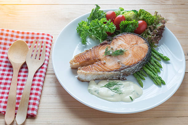 istock Fried salmon with vegetable on a round white plate 579218050