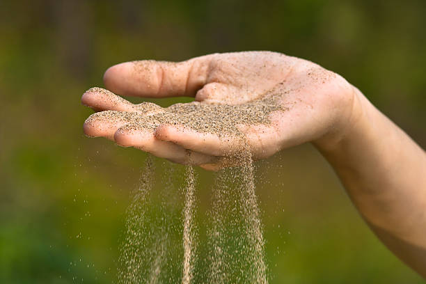 istock sand running through hand like time running out 579219914