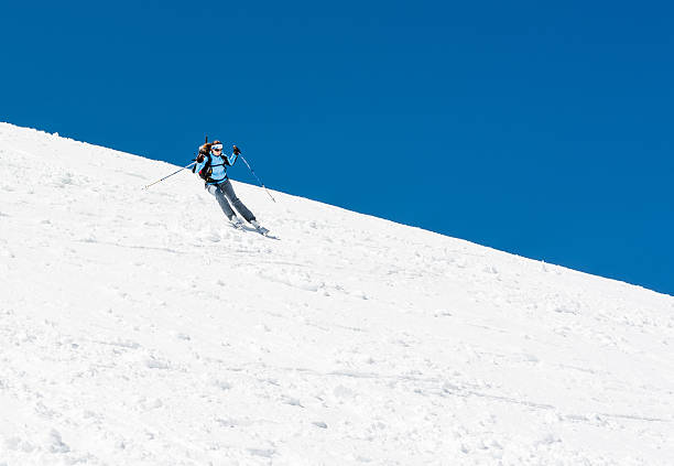 Photo of Female skier tackling a steep slope.