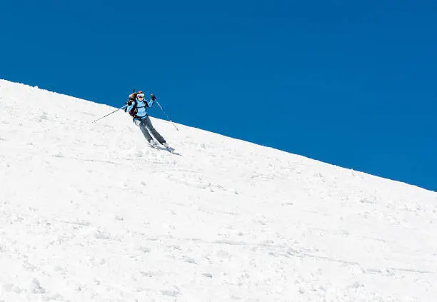 Photo of Female skier tackling a steep slope.