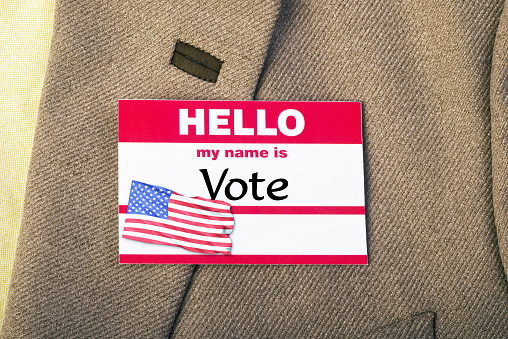 Vote badge on lapel of tweed jacket.