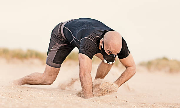 砂浜で働く仮面剃った運動選手 - 這う　男性 ストックフォトと画像