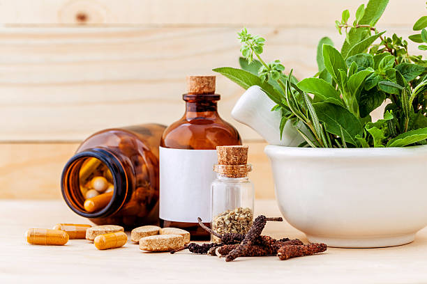 Alternative health care fresh herbal  ,dry and herbal capsule wi Alternative health care fresh herbal  ,dry and herbal capsule with mortar on wooden background. holistic medicine stock pictures, royalty-free photos & images