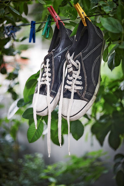 istock Black sneakers are hanging on a clothesline 579227332