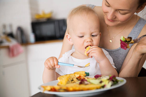 madre e hijo comiendo juntos - baby food fotografías e imágenes de stock