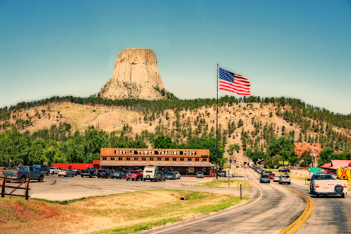 Devils Tower, Wyoming, USA- July 18, 2016: Devils Tower is one of Wyomings most popular monuments with visitors from the Nation over as well as foreign visitors. It is the first natural monument located in the Northeastern Wyoming in 1906 President Teddy Roosevelt designated Devils Tower as the nation's first national monument. This July day the line of visitors were long and a visit to the visitor center parking lot has allmost all the states represented. 