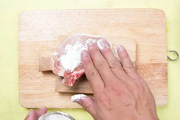 Chef putting flour to raw porkchop / cooking  porkchop steak concept
